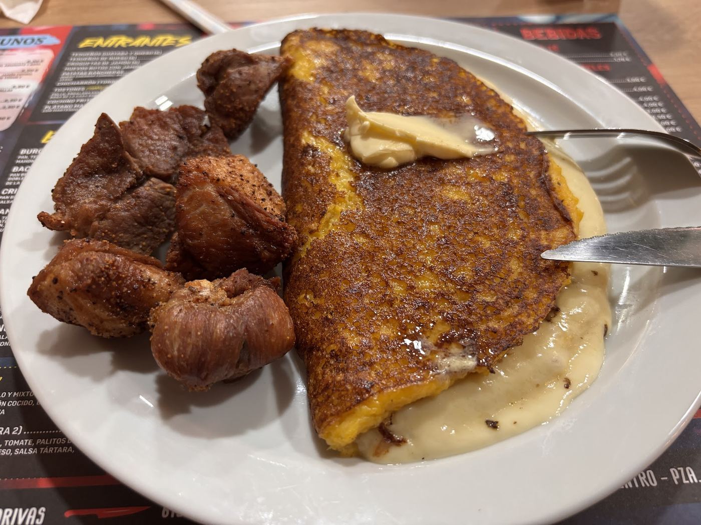 Cachapa venezolana rellena de queso de mano y acompañada de chicharrón.